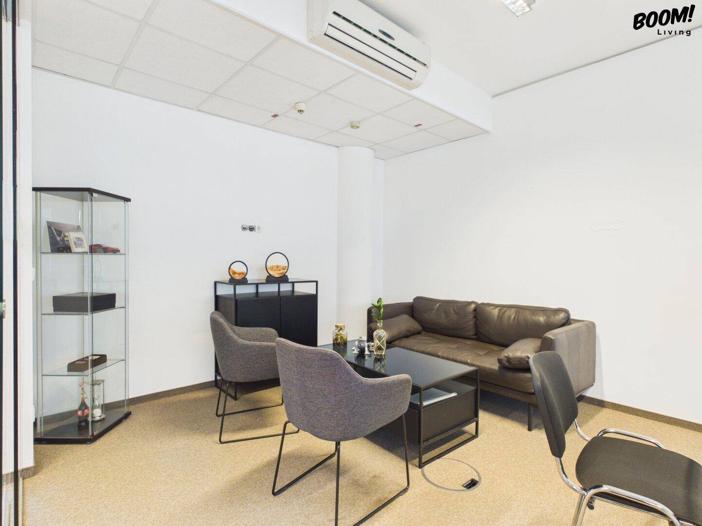 Gemütlicher Loungebereich mit Ledersofa, Sesseln und einem Glastisch, ideal für entspannte Gespräche.