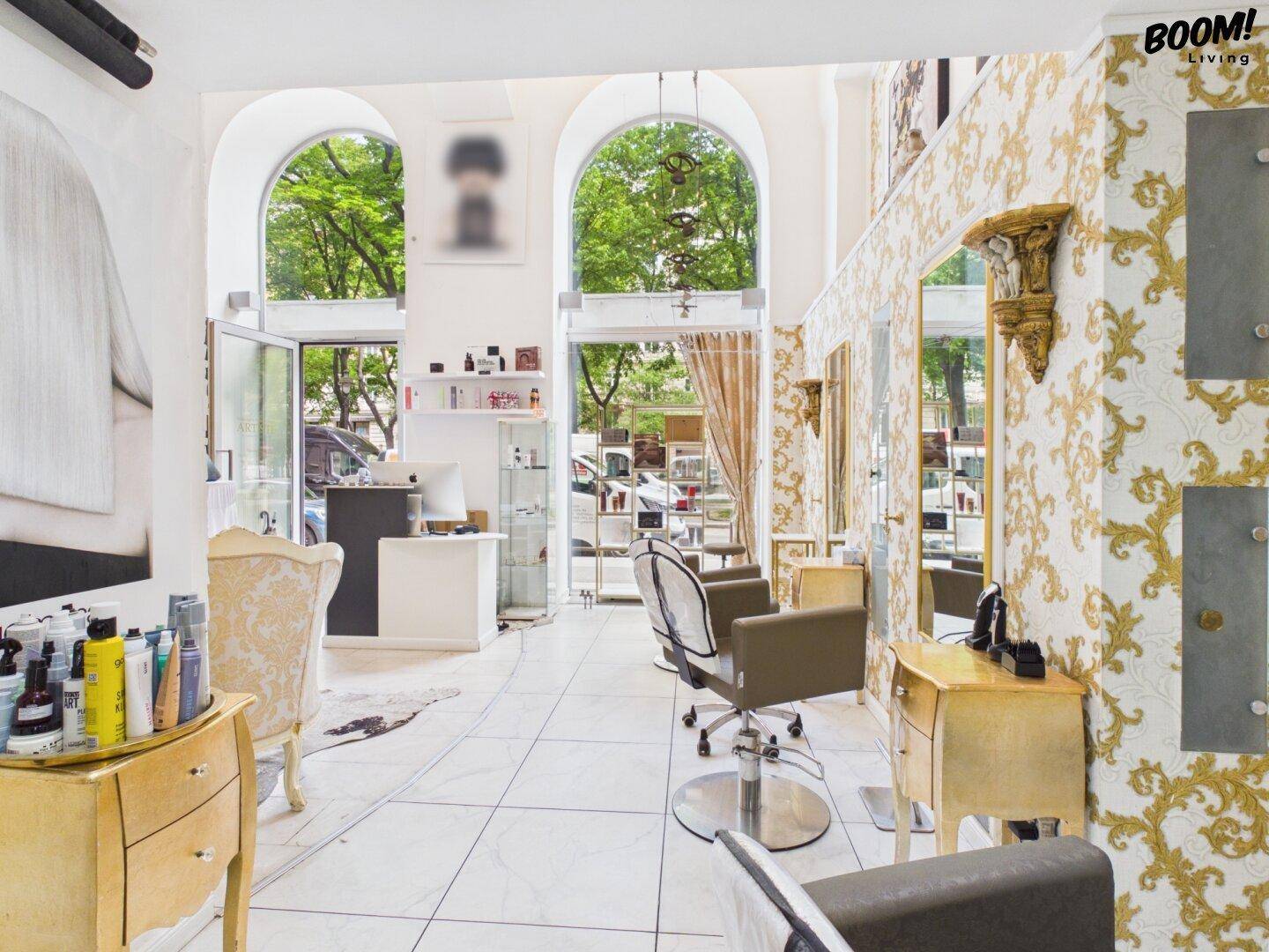 Heller Schönheitssalon mit hohen Bogenfenstern, die viel Tageslicht hereinlassen, und eleganten Frisierplätzen.