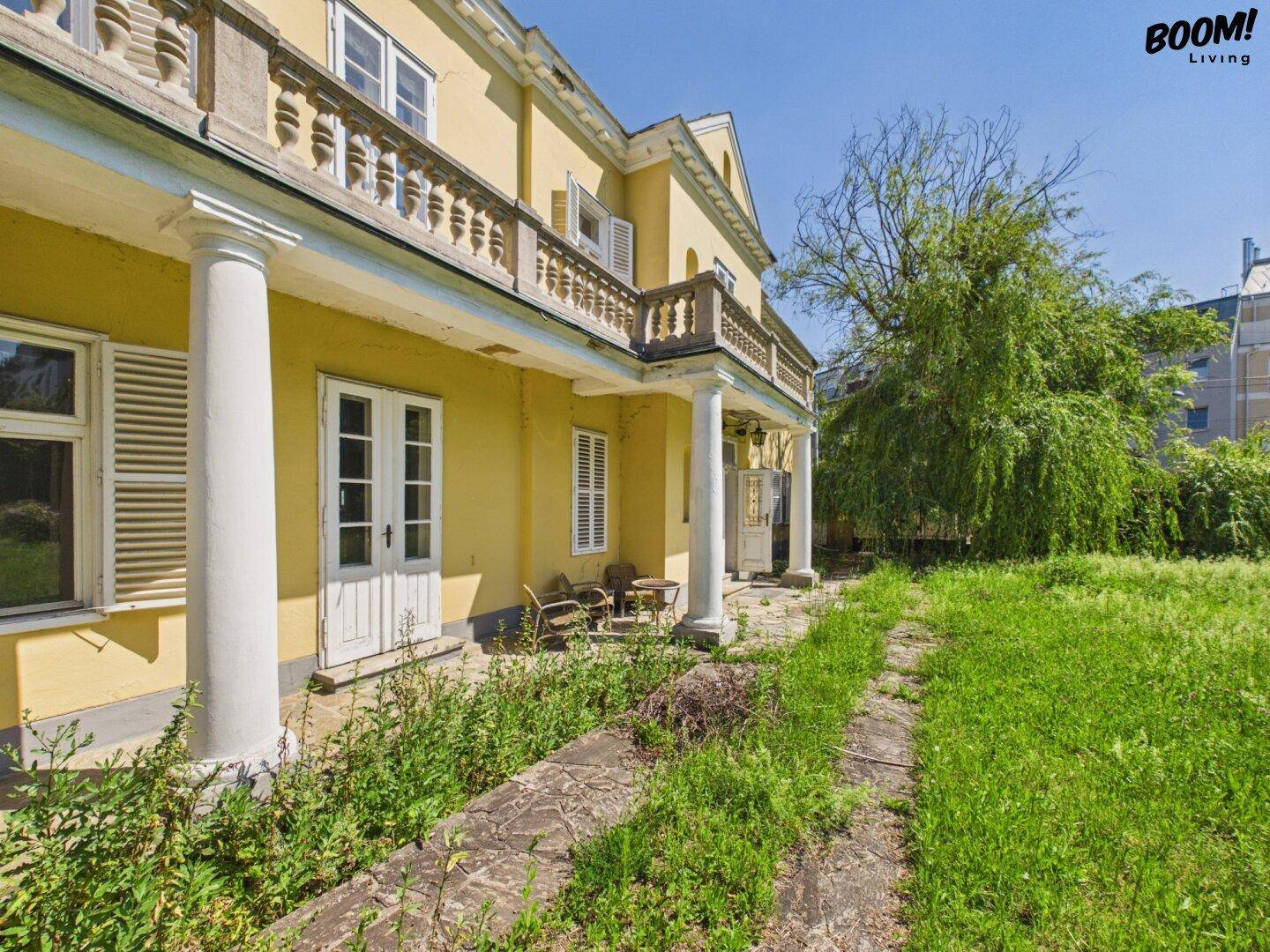 Überdachte Terrasse mit Säulen und Zugang zum Garten, ideal für entspannte Stunden.