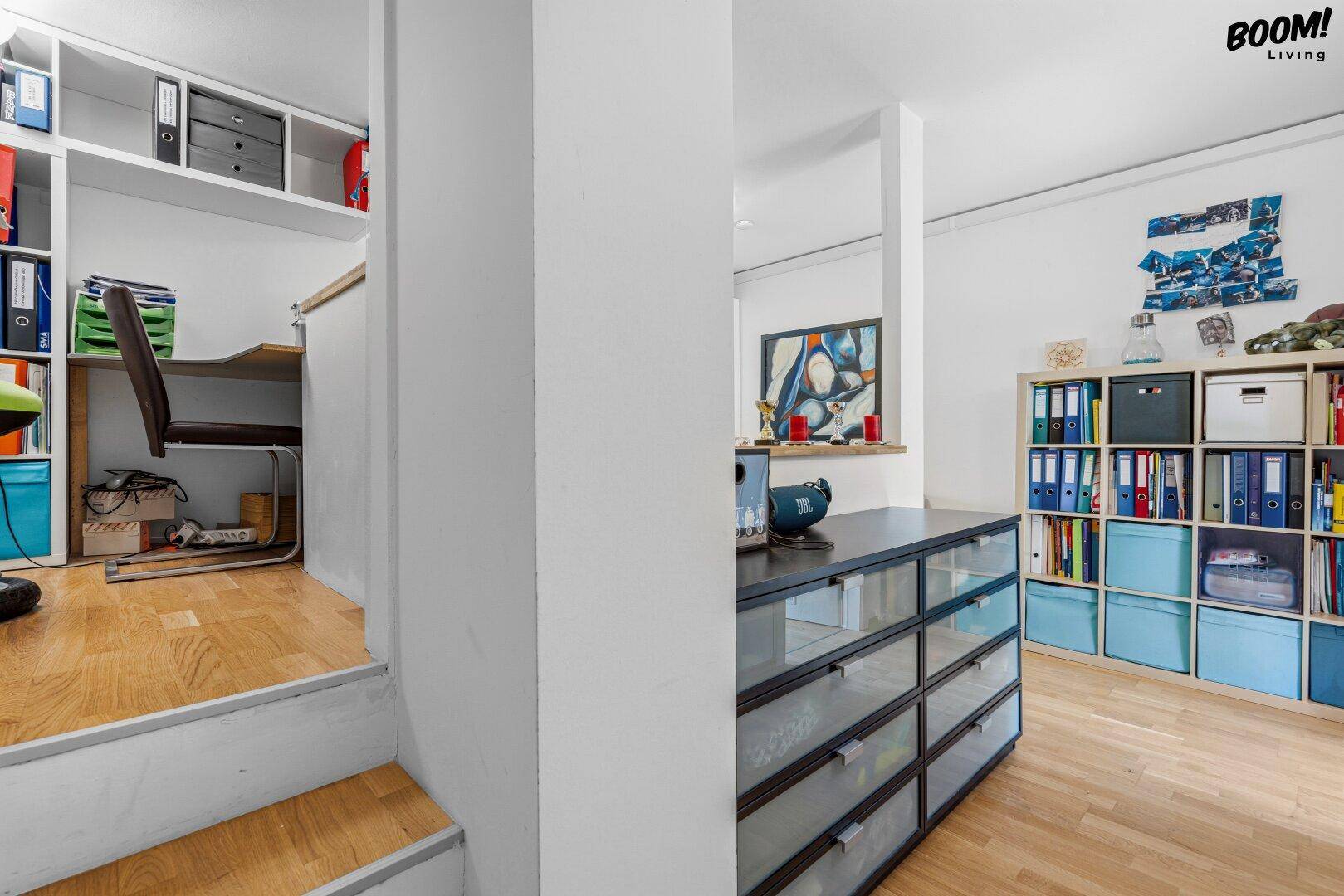 Mehrstufiger Arbeitsbereich mit Holzfußboden und Regalen, ideal für Büro oder Hobby.