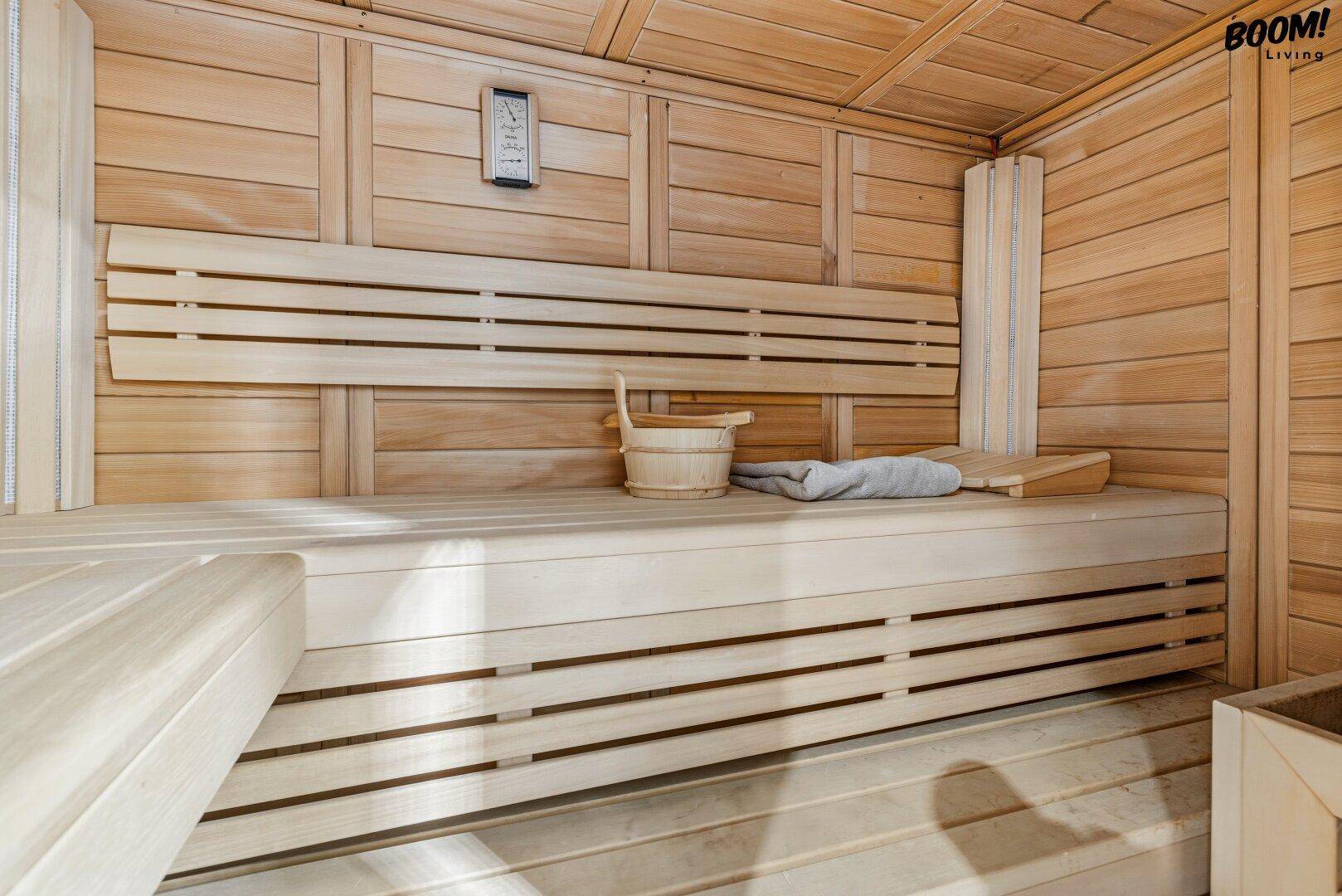Traditionelle Holzsauna mit Bänken und Saunaeimer, ideal zur Entspannung und Wellness.