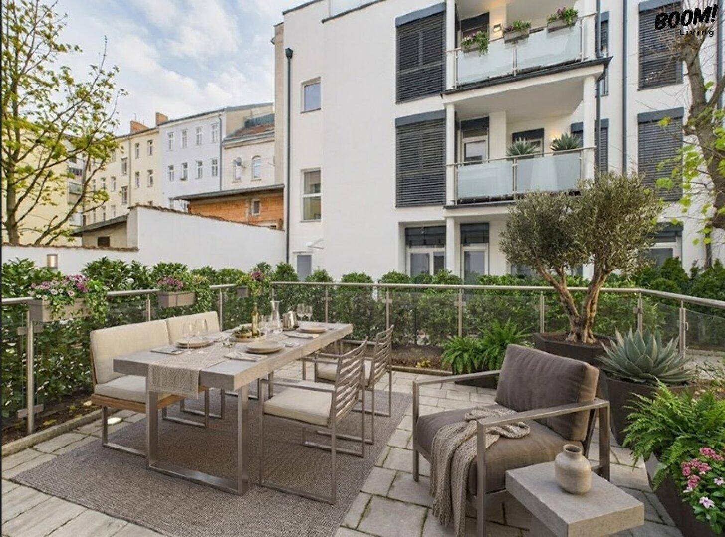 Gemütliche Terrasse mit Esstisch, Lounge-Bereich und Blick auf die begrünte Umgebung.