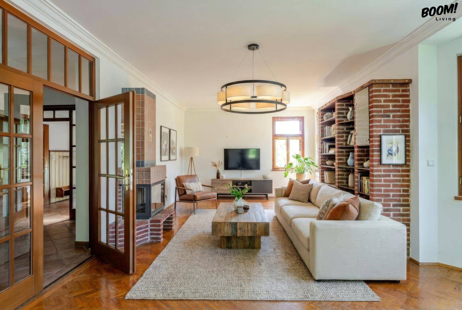 Geräumiges Wohnzimmer mit Parkettboden, Kamin und eingebautem Bücherregal aus Ziegeln.