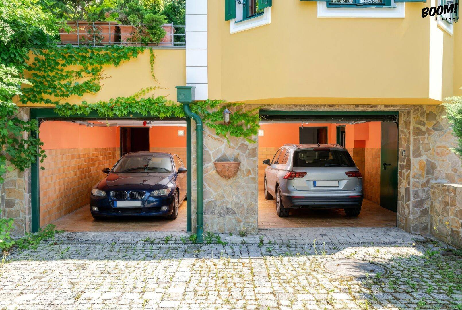 Doppelgarage mit zwei Stellplätzen und Steinfassade unterhalb der Villa.