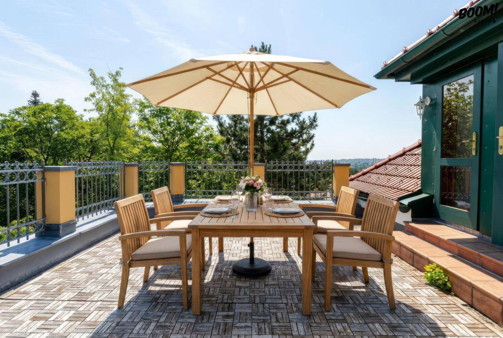 Sonnenterrasse mit Holzboden, Esstisch und Sonnenschirm, umgeben von einer Balustrade.