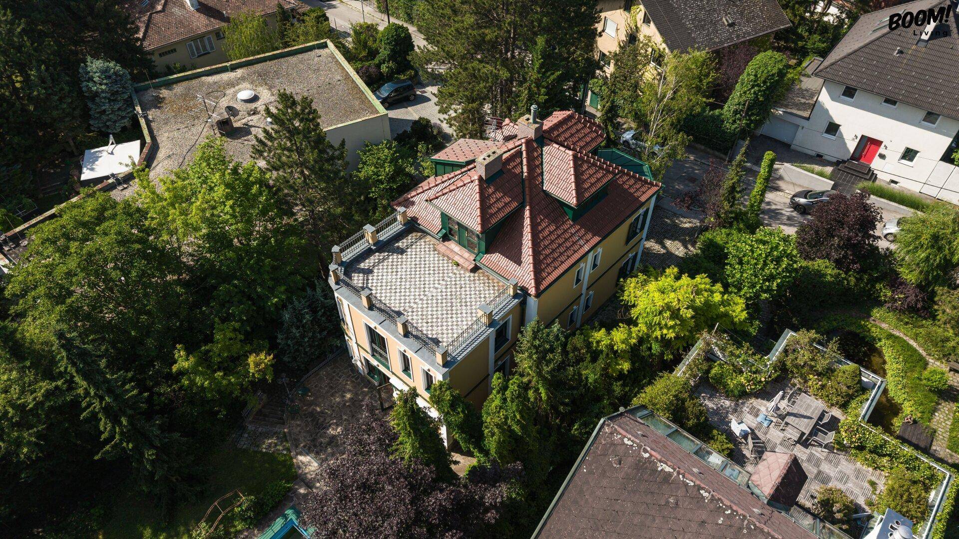 Luftaufnahme der Villa mit Terrassendach und umliegender grüner Landschaft.