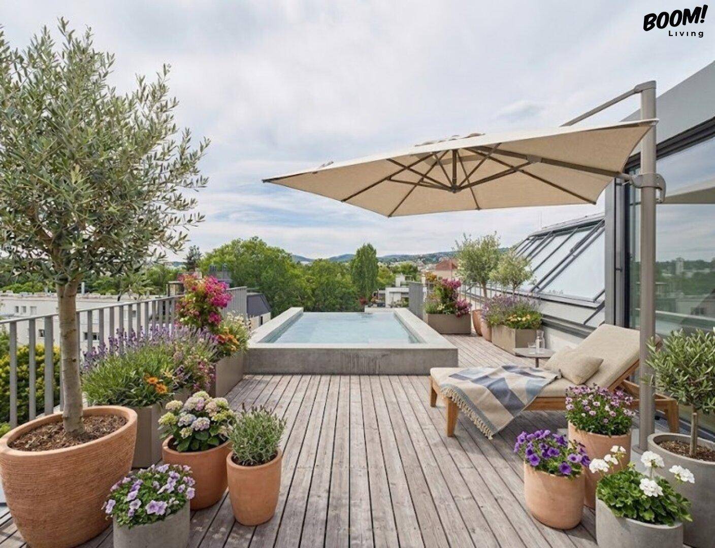 Geräumige Dachterrasse mit Holzdeck, Pflanzen, Liegestuhl und kleinem Pool zum Entspannen.