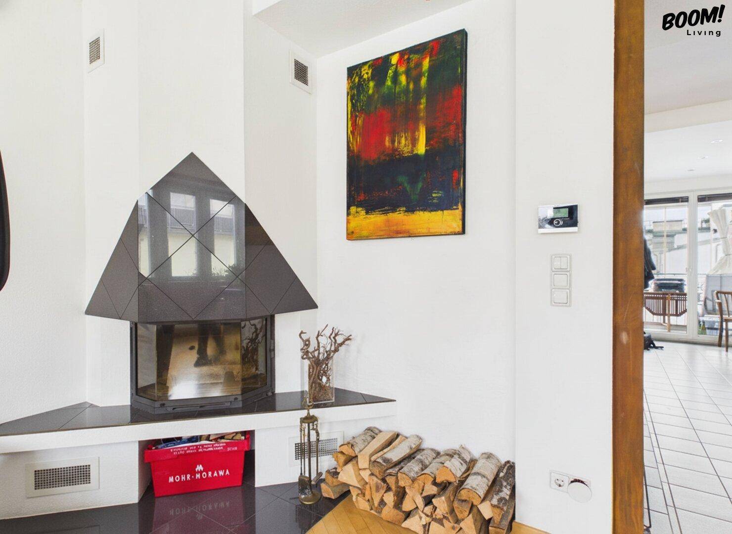 Moderner Kaminbereich mit Holzstapel und abstrakter Kunst an der weißen Wand.