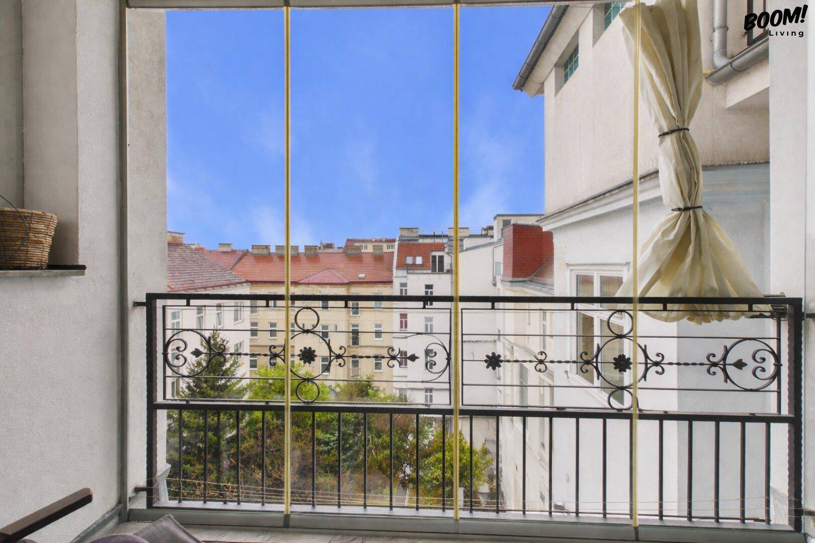 Balkon mit schmiedeeisernem Geländer und Blick auf die umliegenden Gebäude der Stadt.