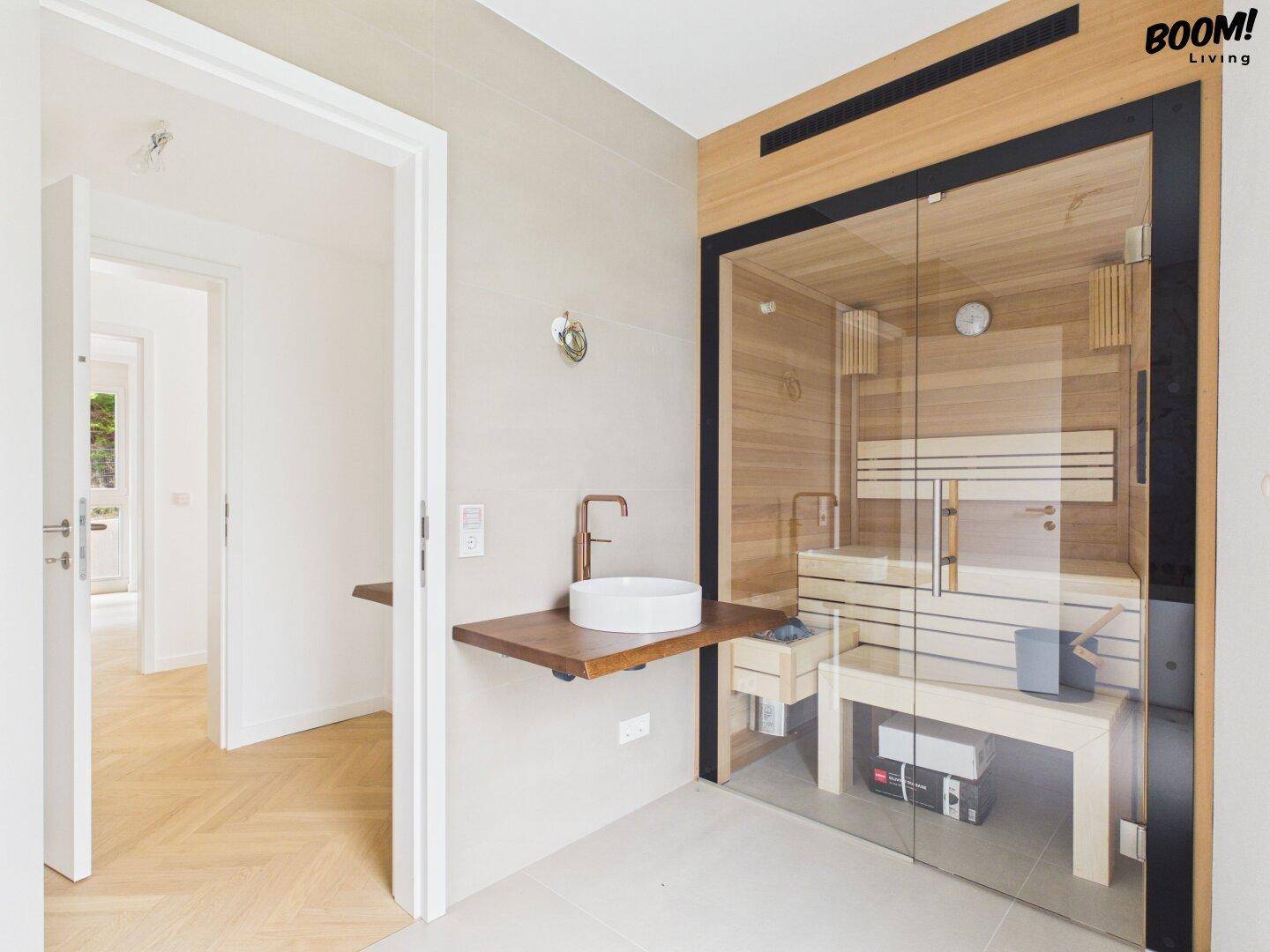 Modernes Badezimmer mit integrierter Sauna, stilvollem Waschbecken und Holzelementen.
