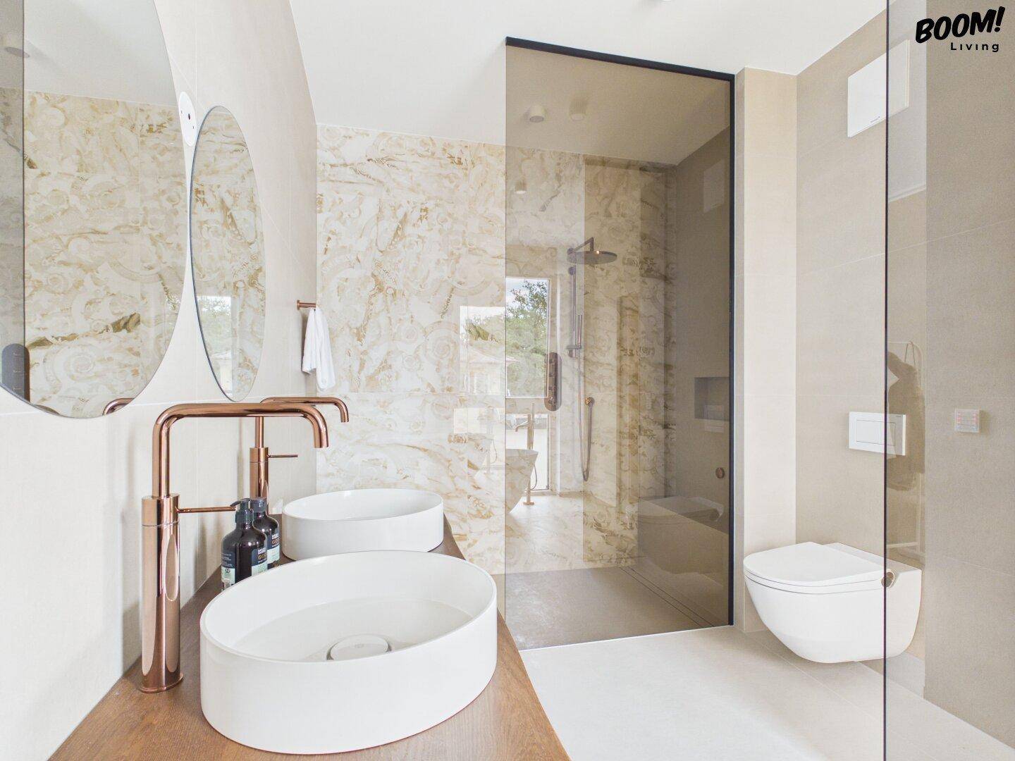Elegantes Badezimmer mit begehbarer Dusche, Doppelwaschbecken und Marmorfliesen.
