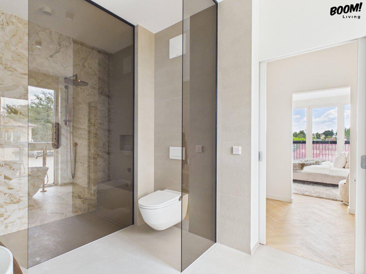 Geräumiges Badezimmer mit begehbarer Dusche und separatem WC, angrenzend an ein Schlafzimmer.