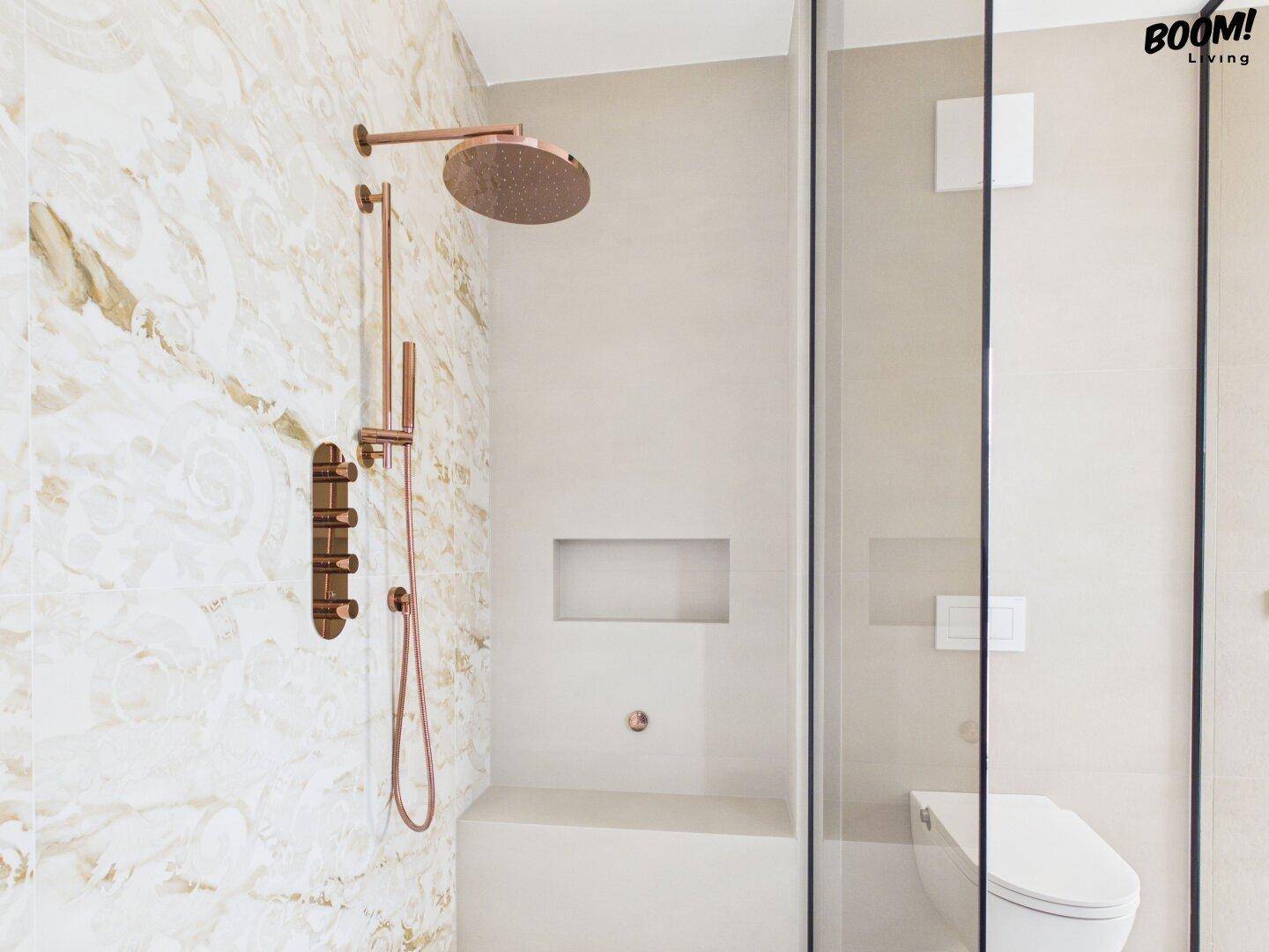 Moderne begehbare Dusche mit Regenduschkopf und eleganten Kupferarmaturen.