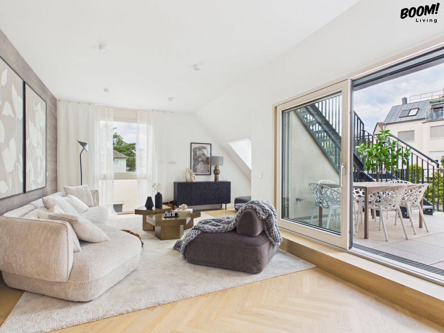 Helles Wohnzimmer mit modernem Design, bequemen Sofas und Zugang zu einer Außenterrasse.