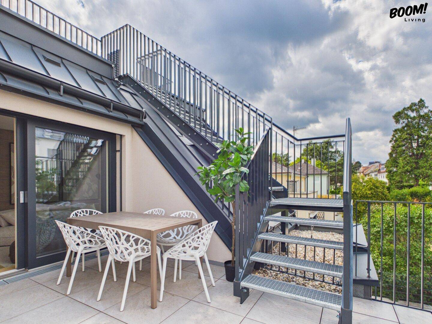 Geräumige Dachterrasse mit Esstisch und Stühlen, ideal für Mahlzeiten im Freien.