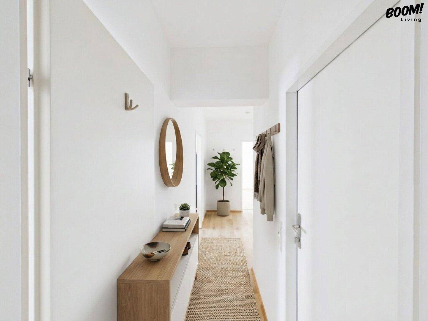 Heller Flur mit minimalistischer Einrichtung, Spiegel und Garderobe.