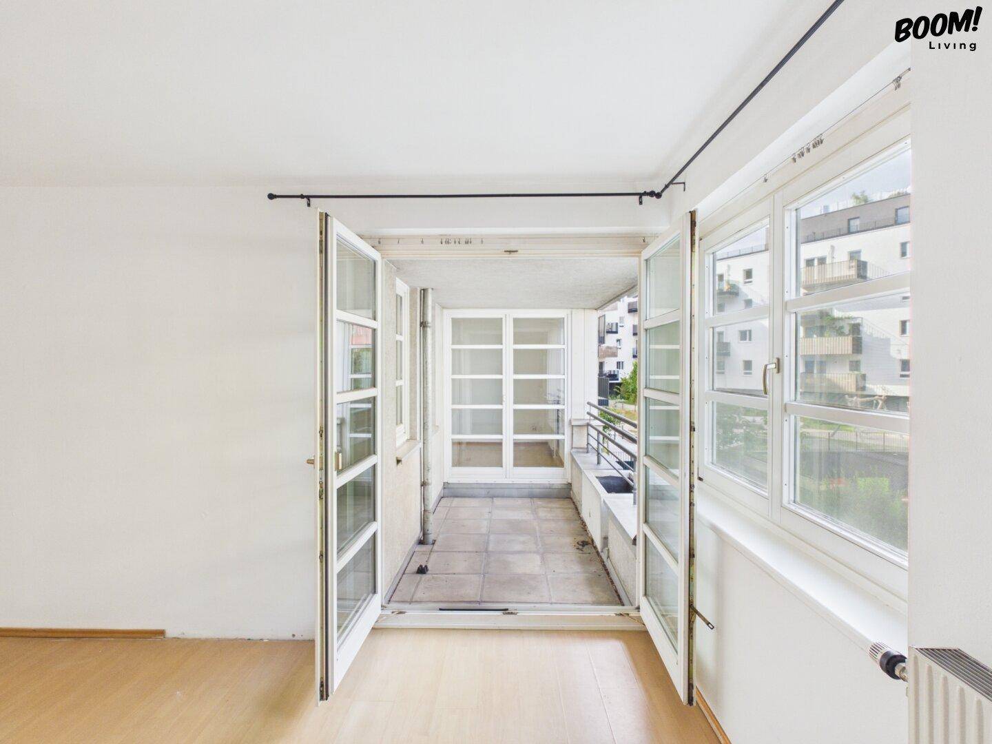 Leerer Raum mit Zugang zu einem verglasten Balkon oder einer Loggia.
