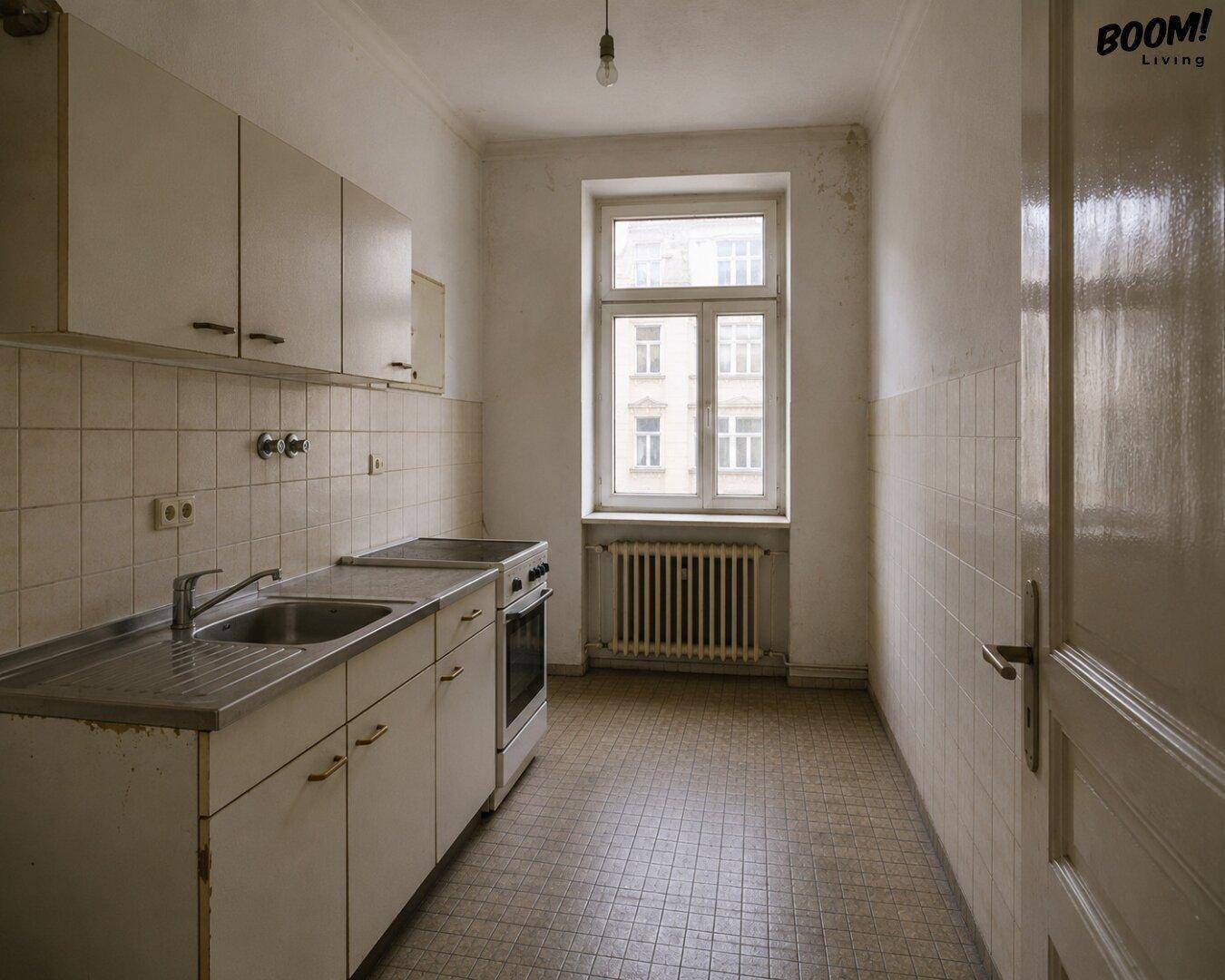 Einfache Küche mit weißen Schränken, Spüle und Herd, bereit für eine Renovierung.