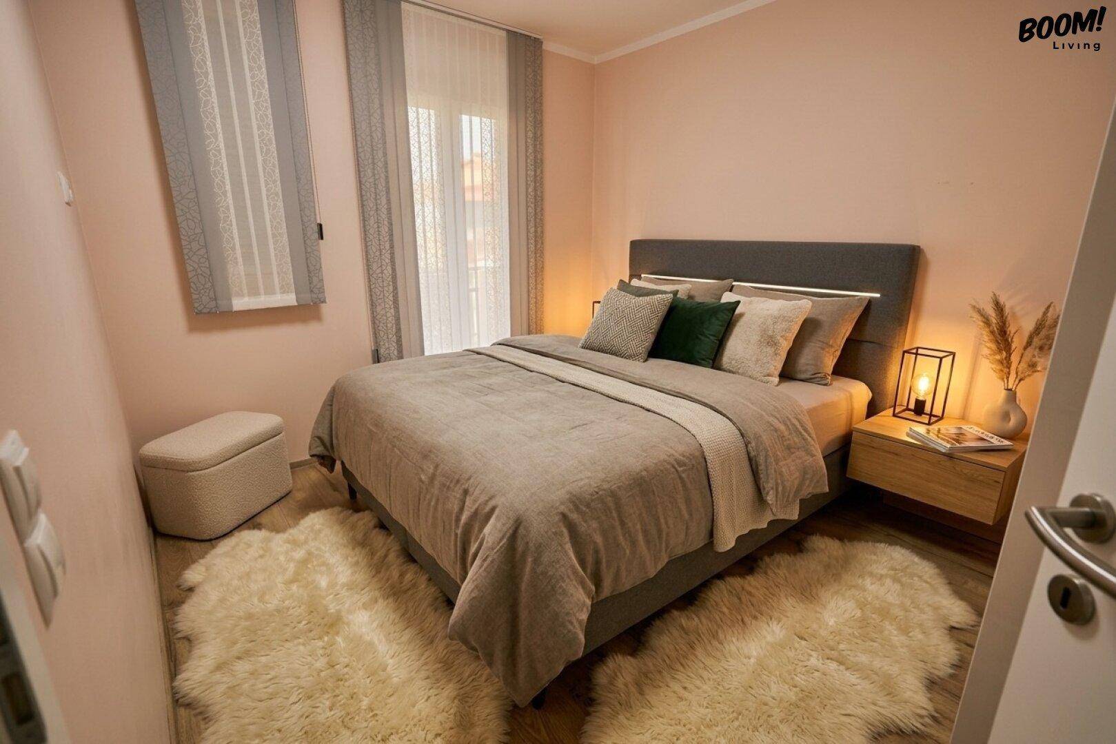 Gemütliches Schlafzimmer mit Doppelbett, zwei Teppichen und einem Fenster mit Vorhängen.