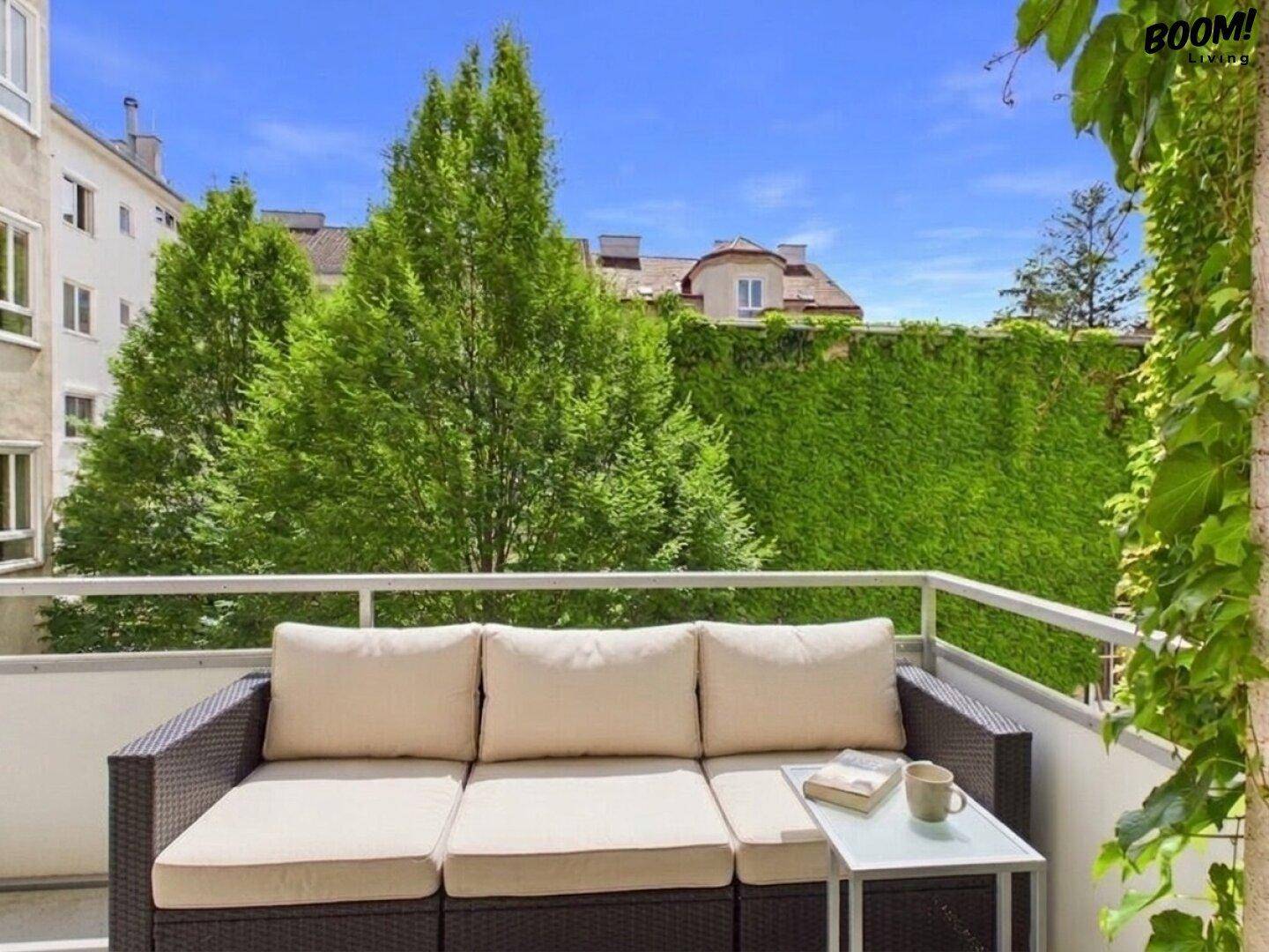 Gemütlicher Balkon mit Sitzgelegenheiten und üppigem Grünblick, ideal zum Entspannen.