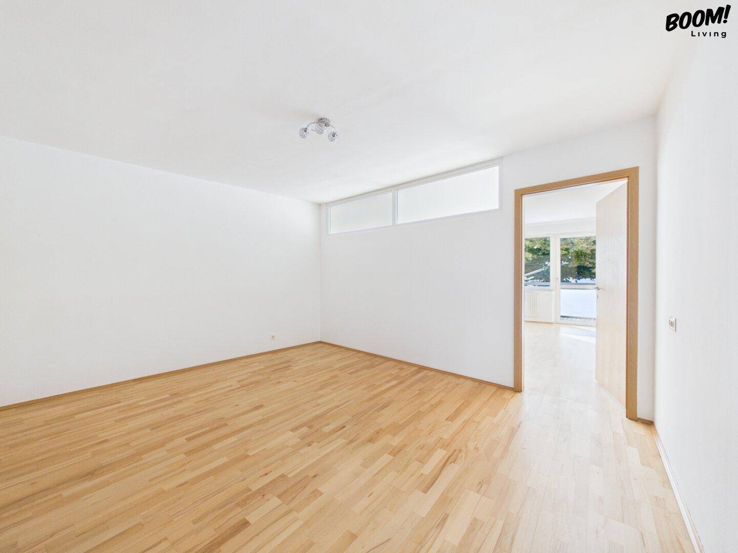 Leeres Zimmer mit Parkettboden und weiß gestrichenen Wänden, bereit für neue Bewohner.