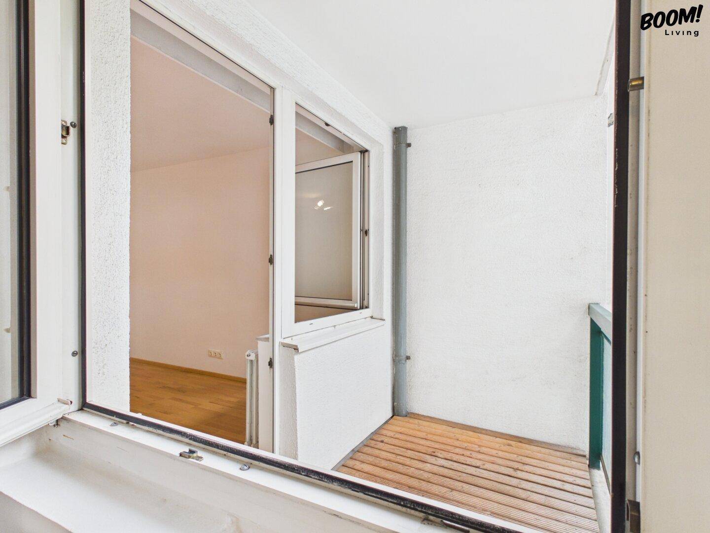 Kleiner Balkon mit Holzboden und Blick auf den Innenhof, zugänglich vom Zimmer.