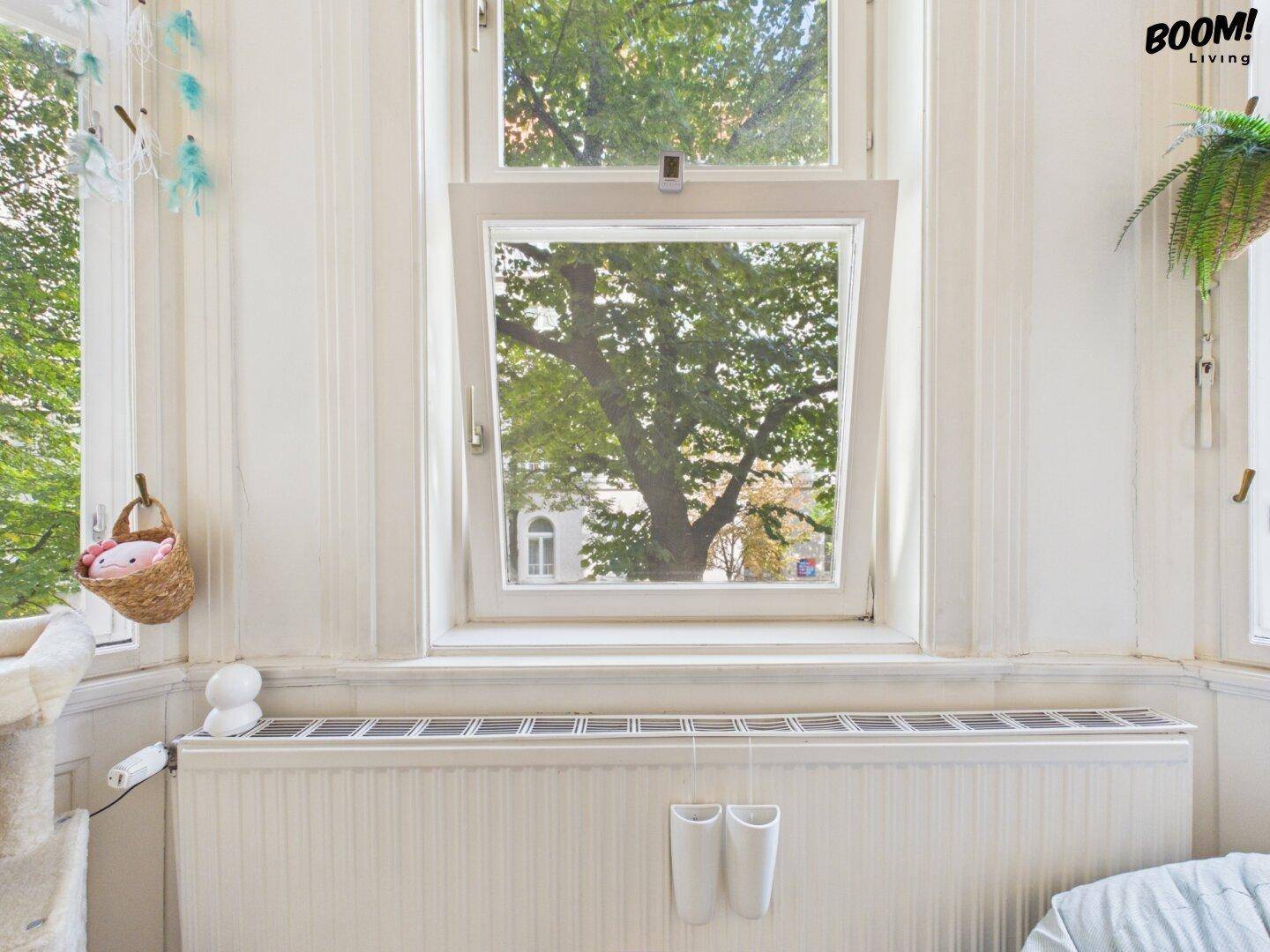 Großes Fenster mit Blick ins Grüne und Heizkörper darunter, bietet viel natürliches Licht.