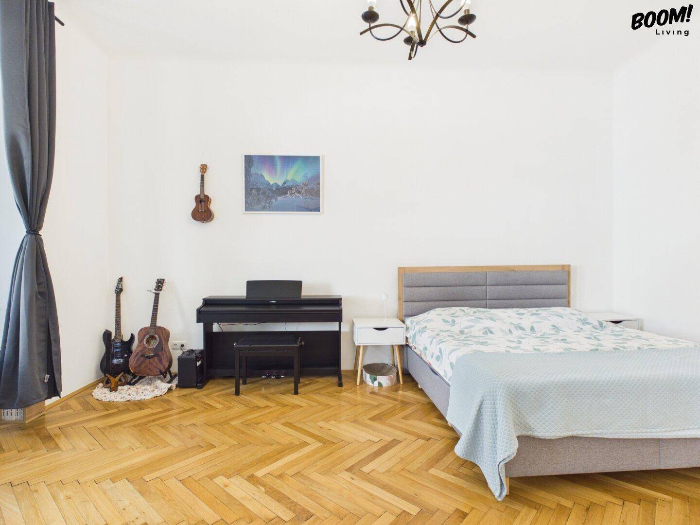 Geräumiges Schlafzimmer mit Doppelbett, Klavier und Musikinstrumenten, Fischgrätparkett.