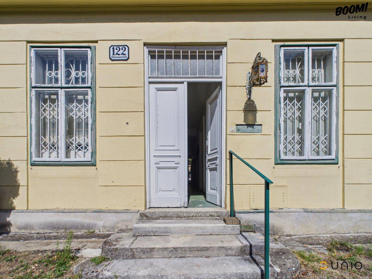 Eingangsbereich eines historischen Gebäudes mit Hausnummer 122 und traditioneller Architektur.