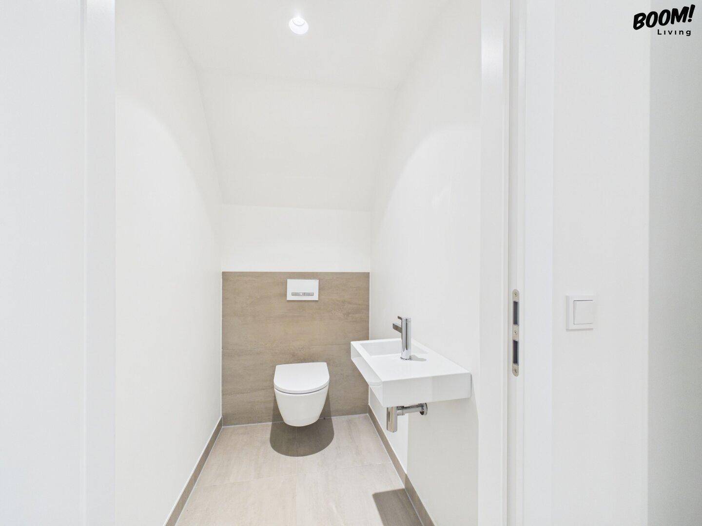 Modernes Gäste-WC mit wandhängender Toilette und kleinem Waschbecken.