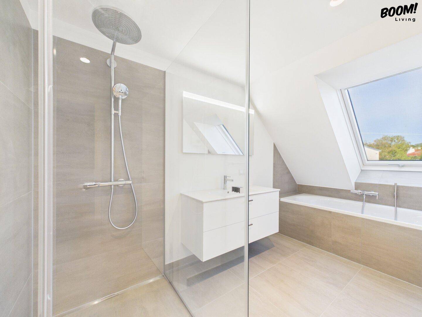 Modernes Badezimmer mit begehbarer Dusche, Badewanne und Dachfenster.