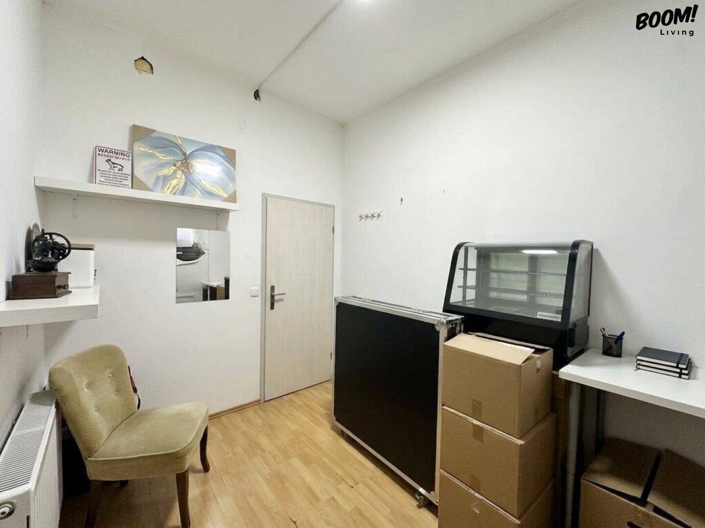Lagerraum mit Holzboden, einem Display-Schrank und Regalen an der Wand.