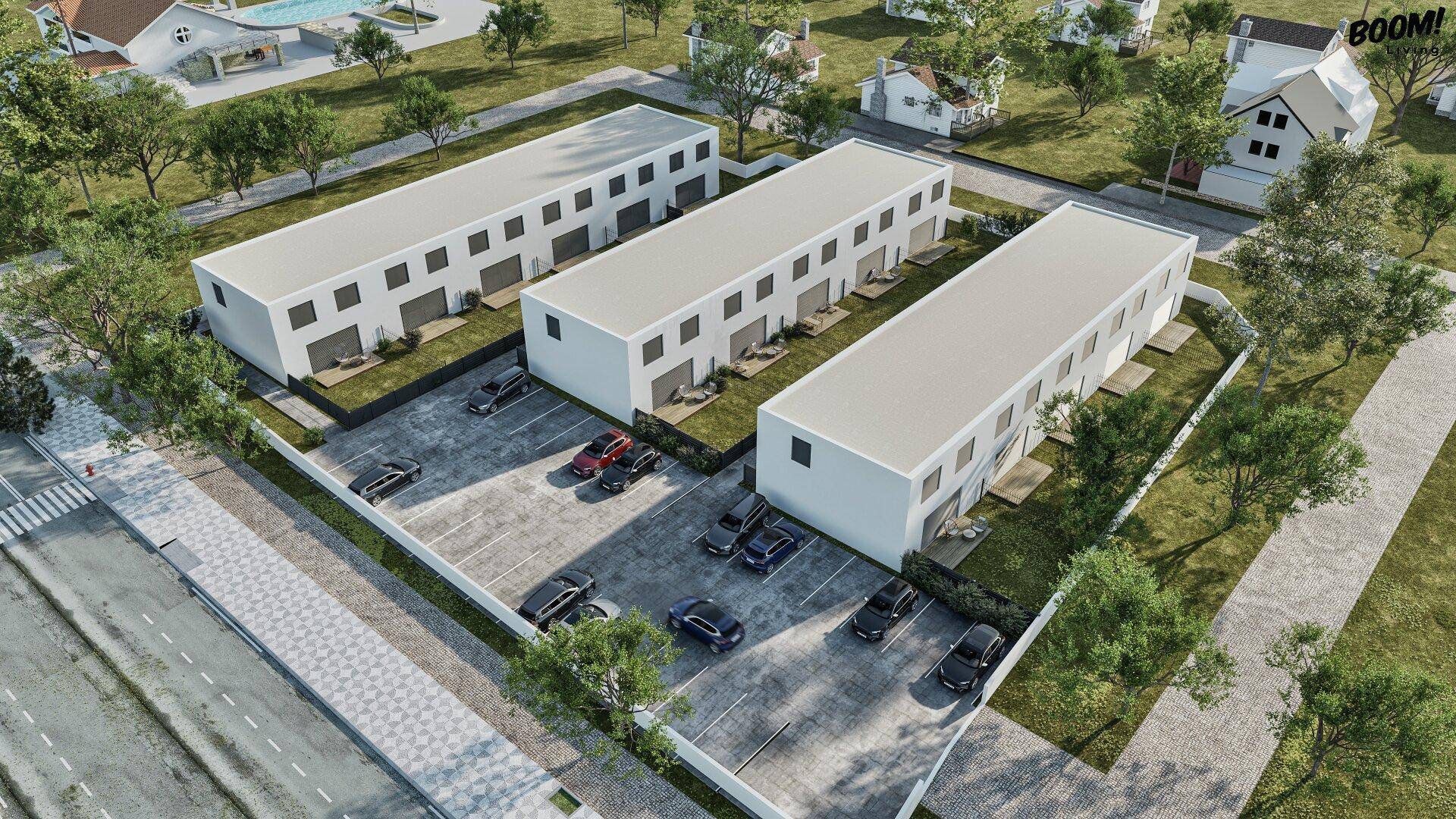 Luftaufnahme einer modernen Wohnsiedlung mit Reihenhäusern, Parkplätzen und gepflegten Grünflächen.