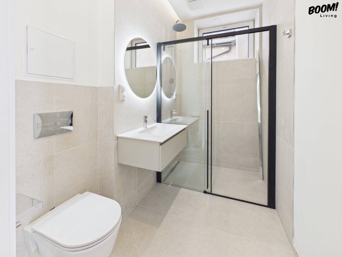 Modernes Badezimmer mit begehbarer Dusche, wandhängendem WC und beleuchtetem Spiegel.