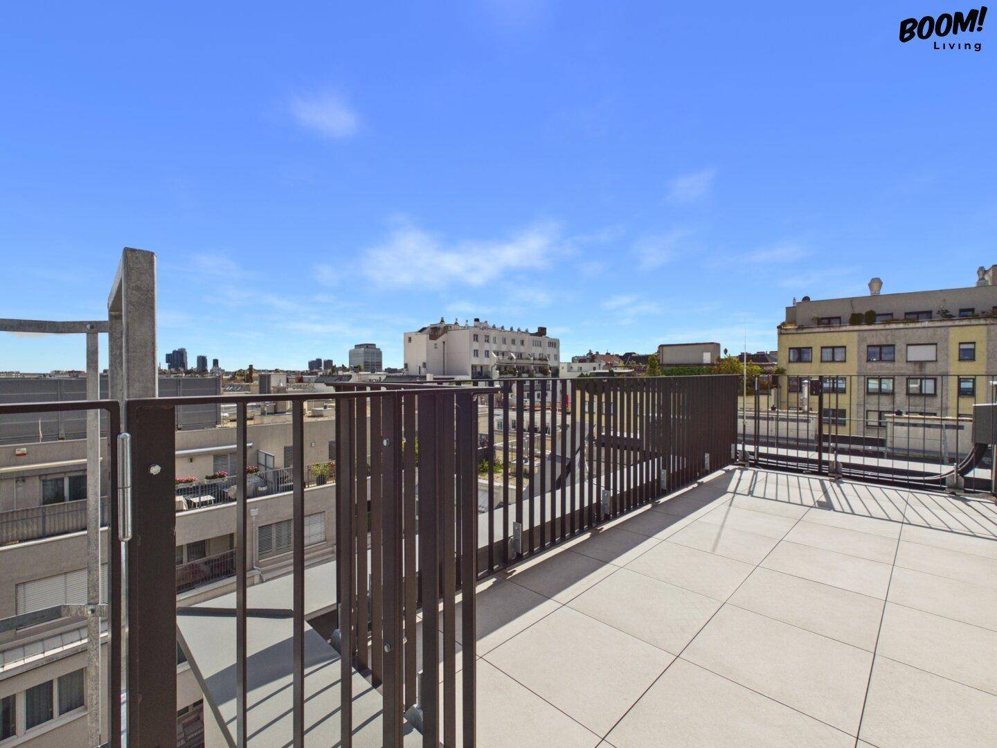 Geräumige Dachterrasse mit Fliesenboden und weitem Blick über die Stadt.