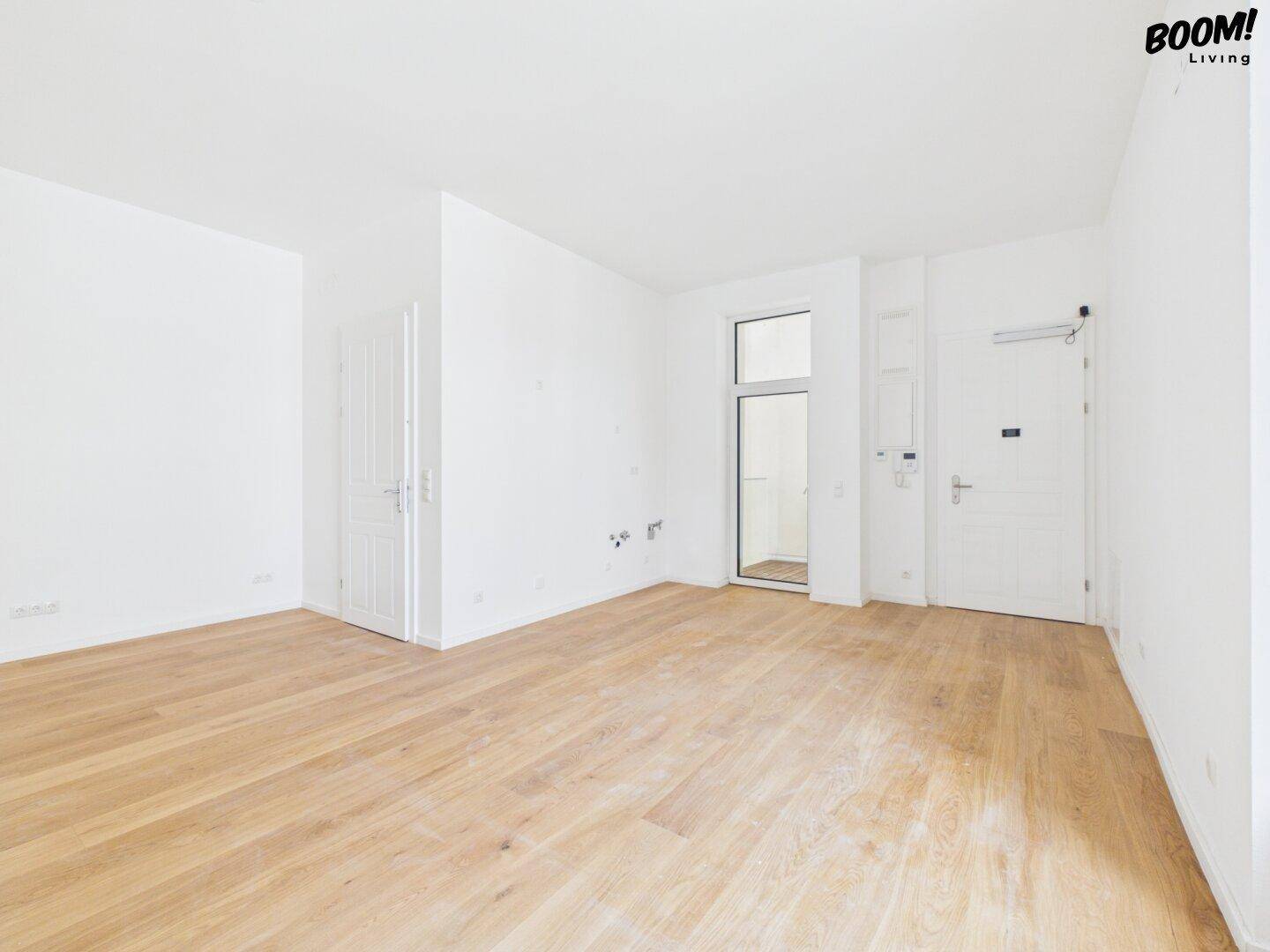 Leerer, heller Raum mit Holzboden und Zugang zu einem Außenbereich, ideal für individuelle Gestaltung.