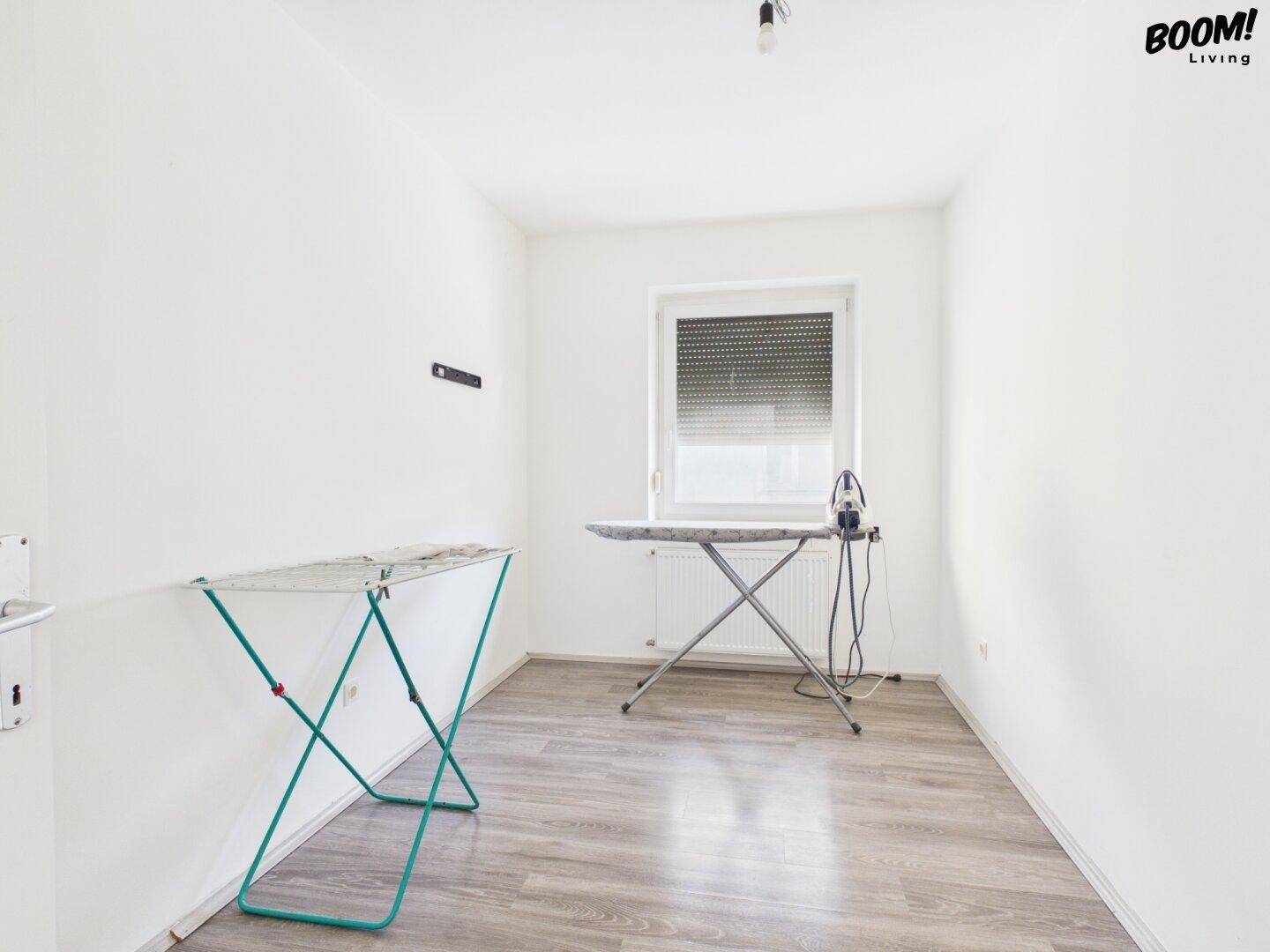 Helles Zimmer mit Fenster, Heizung und Platz für Haushaltsarbeiten.