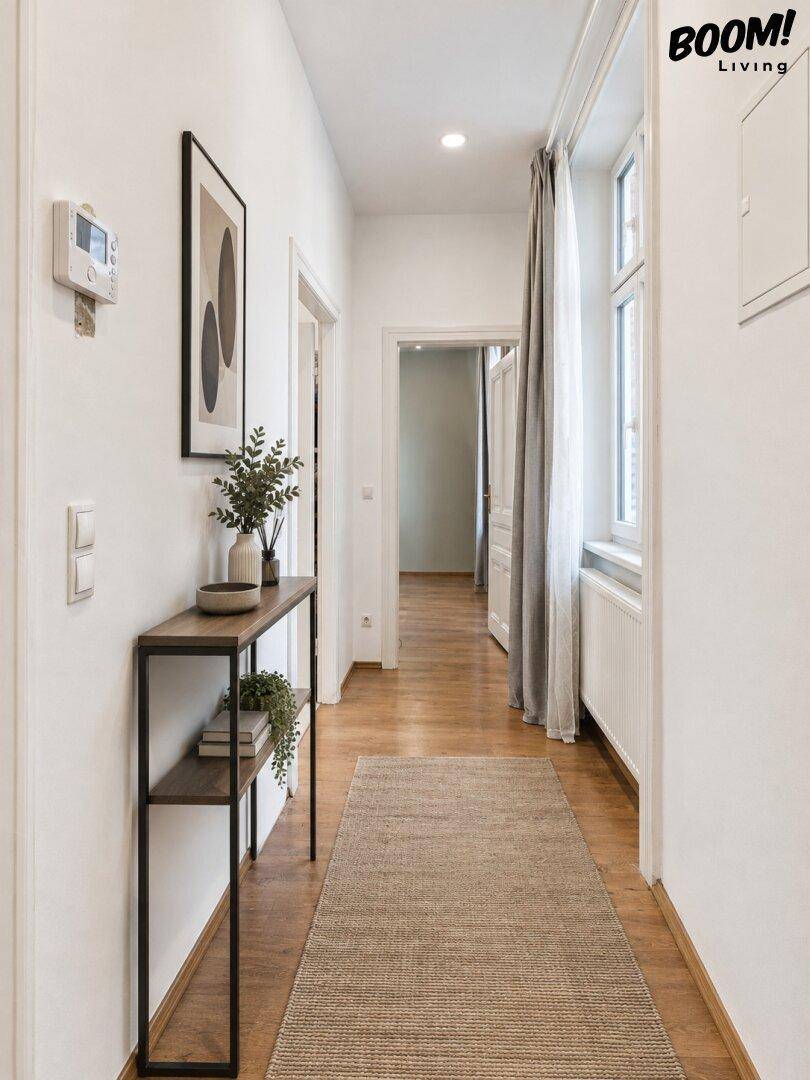 Heller Flur mit Holzboden und einem schmalen Konsolentisch, der den Eingangsbereich freundlich gestaltet.