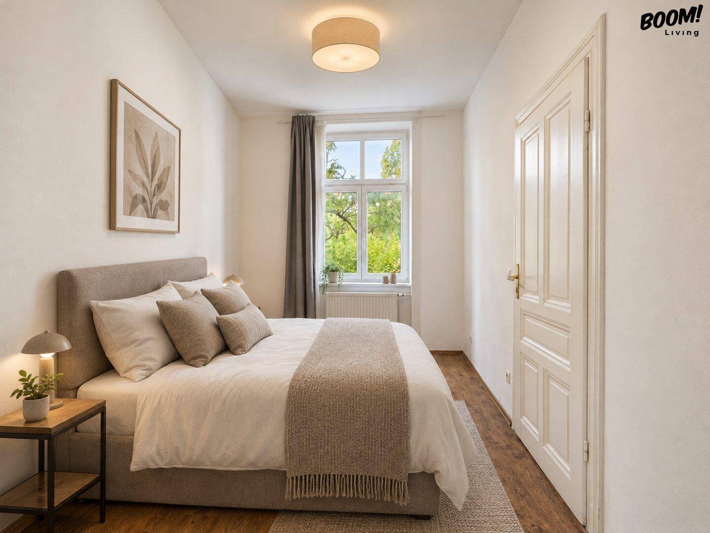 Gemütliches Schlafzimmer mit Doppelbett, Holzboden und Blick ins Grüne durch das große Fenster.