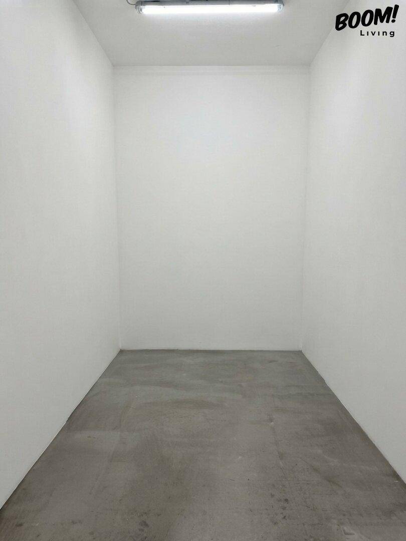 Leerer, schmaler Raum mit weißen Wänden und Betonboden, ideal als Abstellraum nutzbar.