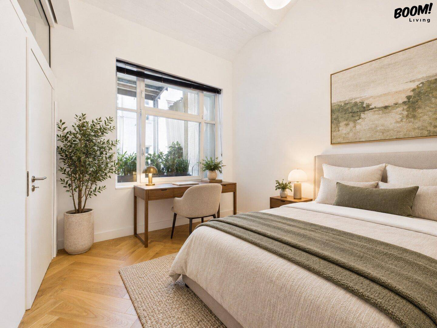 Gemütliches Schlafzimmer mit Fischgrätparkett, Schreibtisch und Blick auf den Innenhof.
