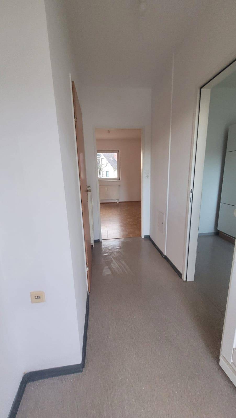 Heller Flur mit strapazierfähigem Bodenbelag, der zu weiteren Räumen führt.