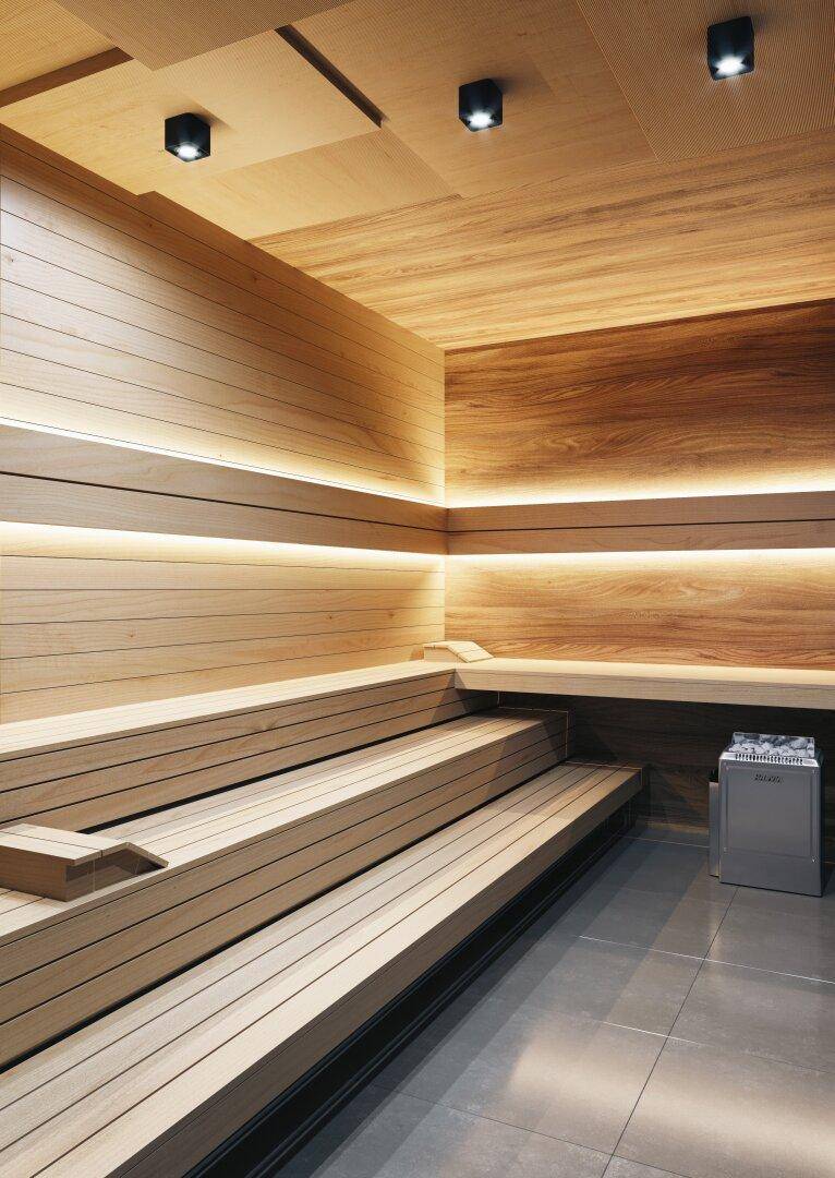 Moderne Holzsauna mit indirekter Beleuchtung und mehreren Sitzebenen für Entspannung.