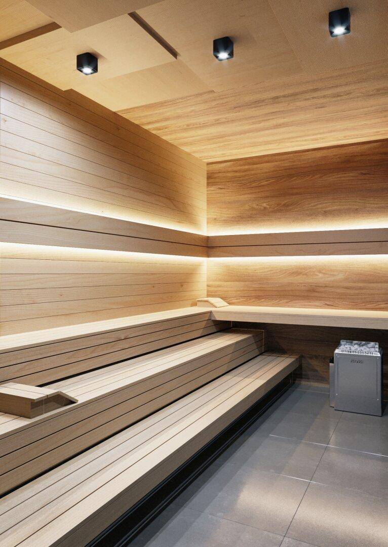 Moderne Sauna mit Holzverkleidung, indirekter Beleuchtung und bequemen Bänken zum Entspannen.