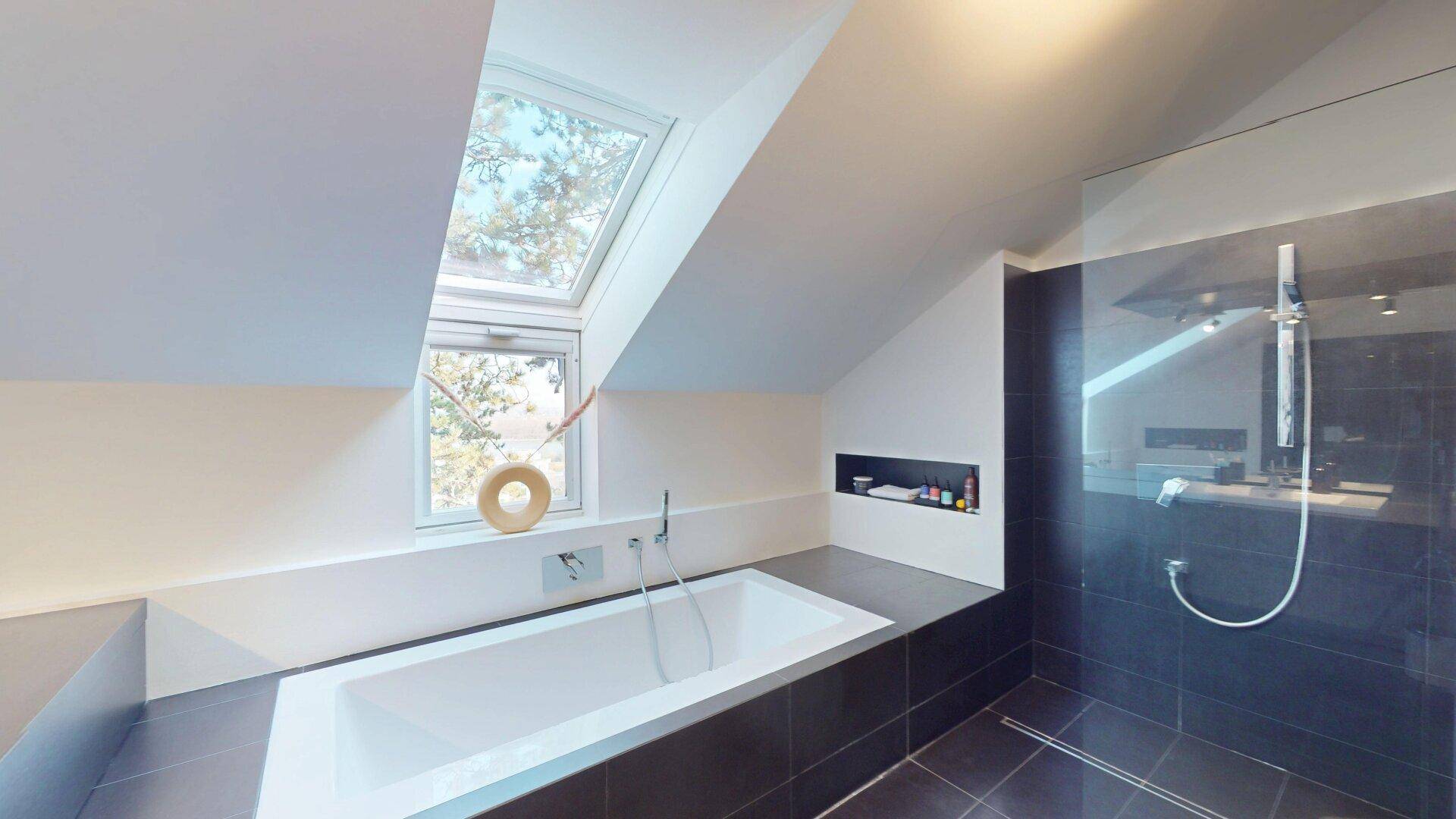 Modernes Dachgeschossbad mit eingebauter Badewanne, begehbarer Dusche und Dachfenster.
