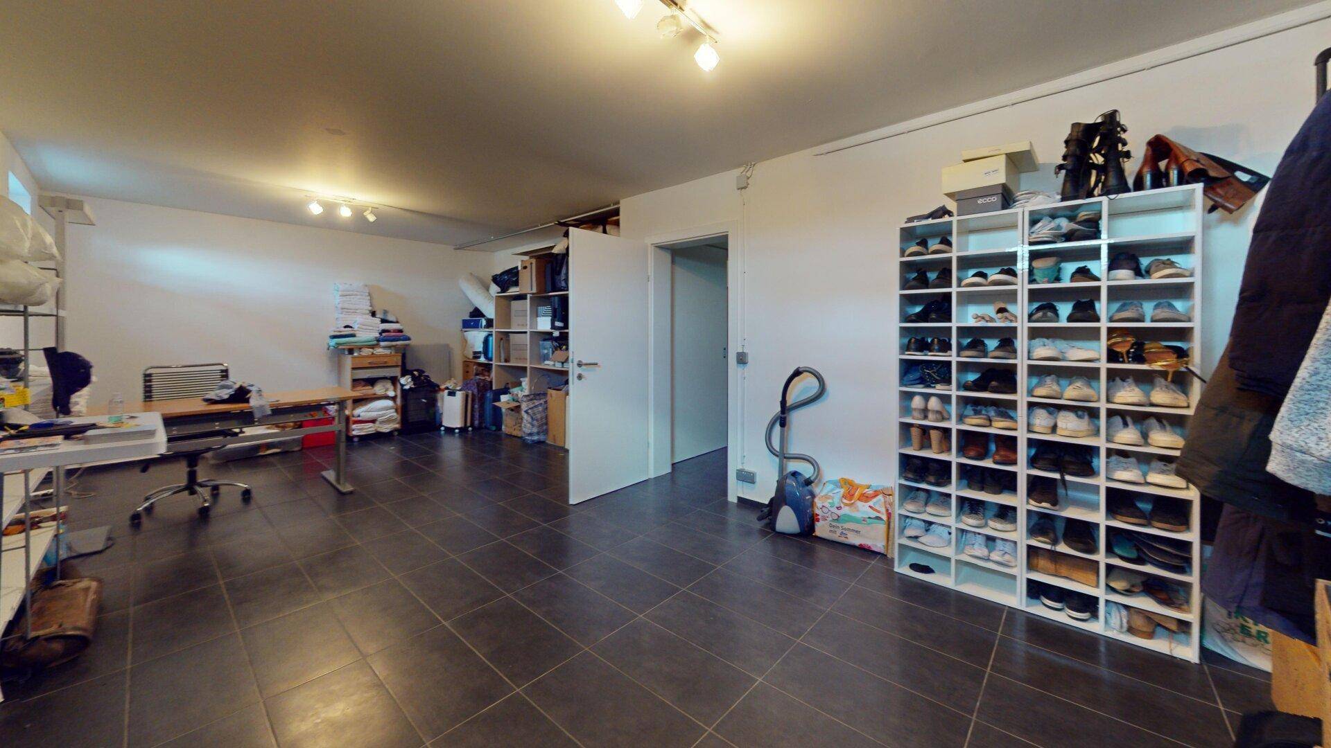 Großer Abstellraum mit Schuhregalen und viel Platz für Lagerung und Organisation.
