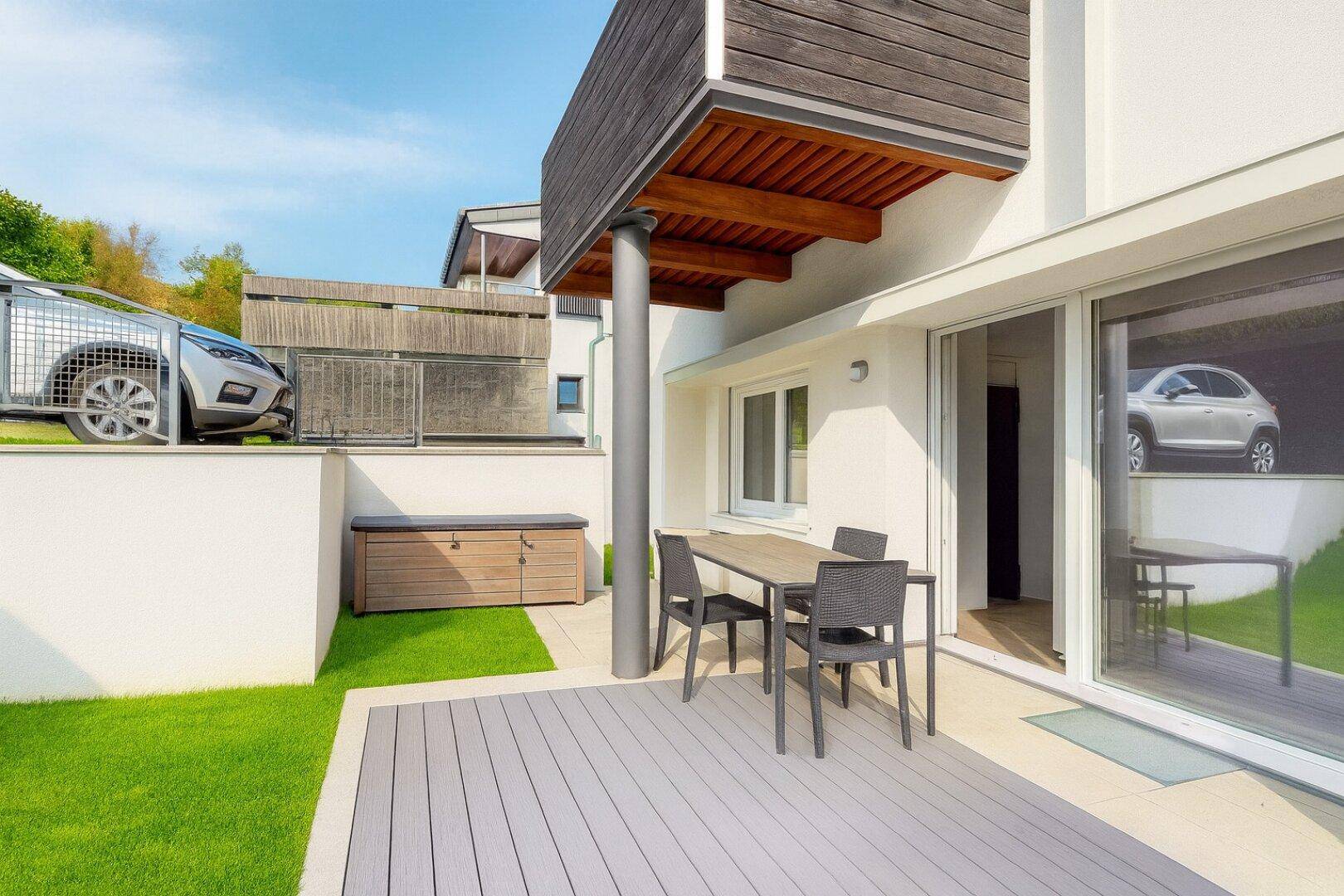 Geräumige Terrasse am Haus mit Holzboden und direktem Zugang zum Innenbereich.