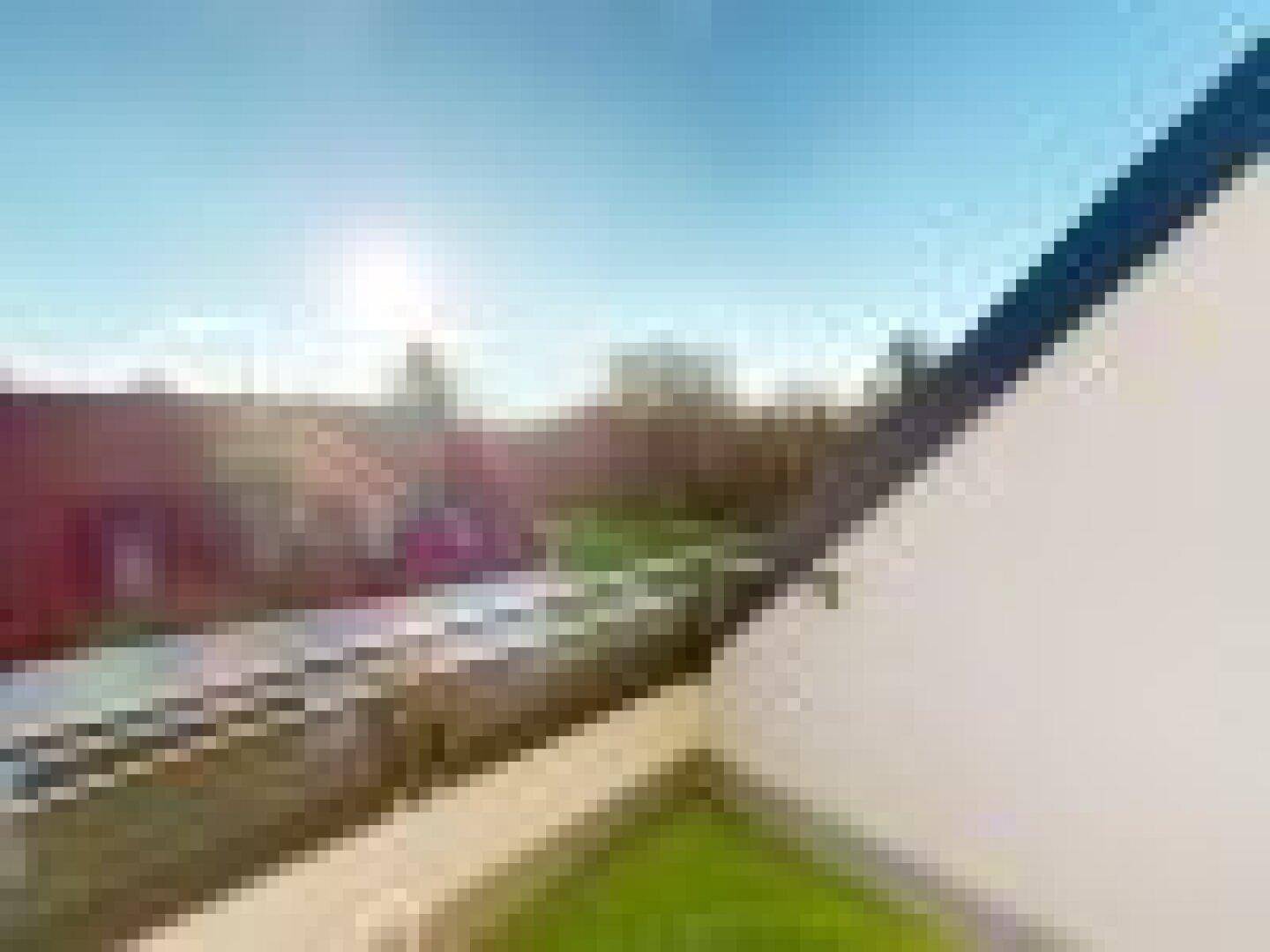 Verschwommene Dachlandschaft mit Blick auf die umliegende Bebauung und den blauen Himmel.
