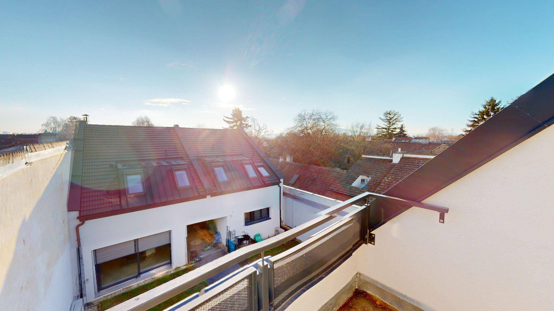 Dachlandschaft des Gebäudes mit Blick auf die umliegende Bebauung und einen Dachterrassenbereich.