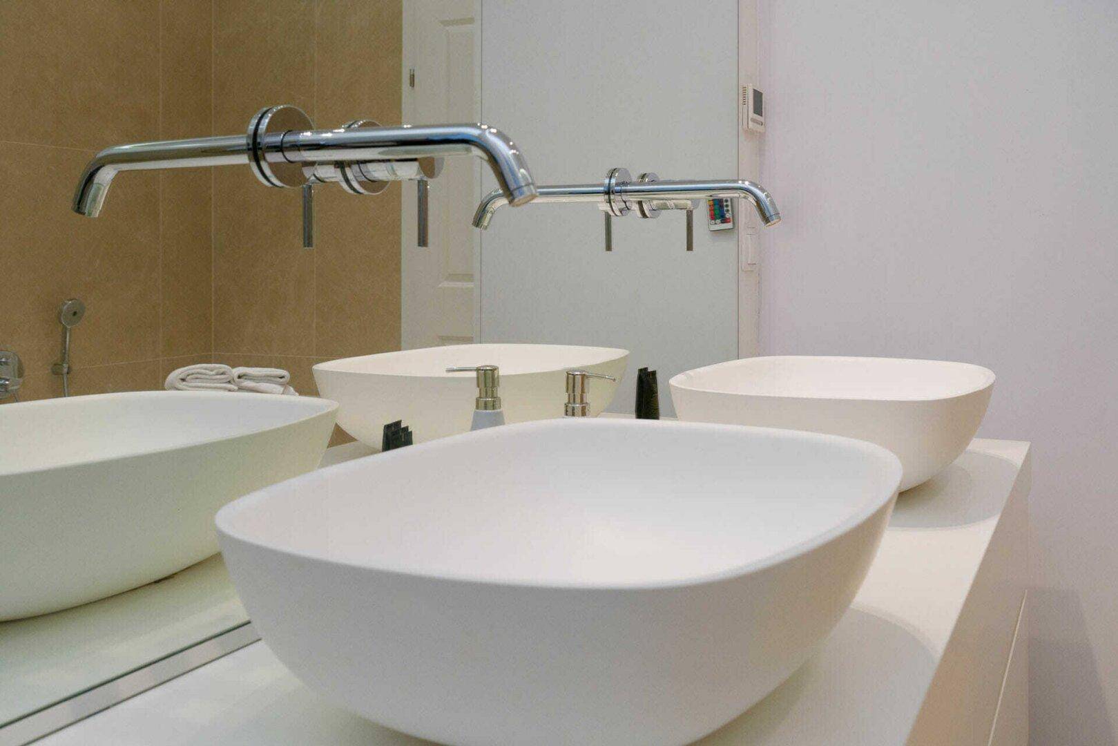 Detailaufnahme der modernen Aufsatzwaschbecken und Wandarmaturen im Badezimmer.